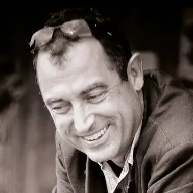 Homme souriant en noir et blanc.