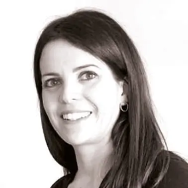 Portrait d'une femme souriante en noir et blanc.