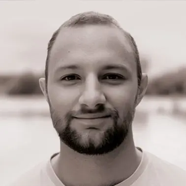 Portrait homme souriant en noir et blanc.